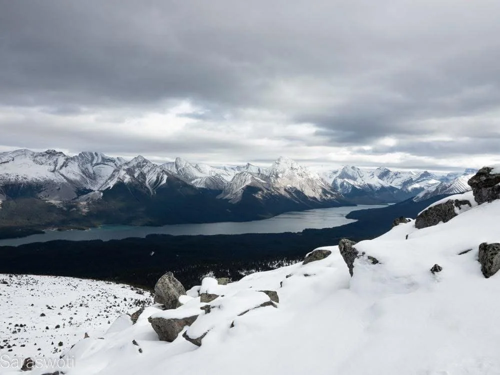 Thanksgiving weekend from the Bald Hills: an early, knee-high snow transformed Maligne Lake below. At the peak, the wind whistled over a revealed truth—that every summit only shows you the next layer of mountain waiting.