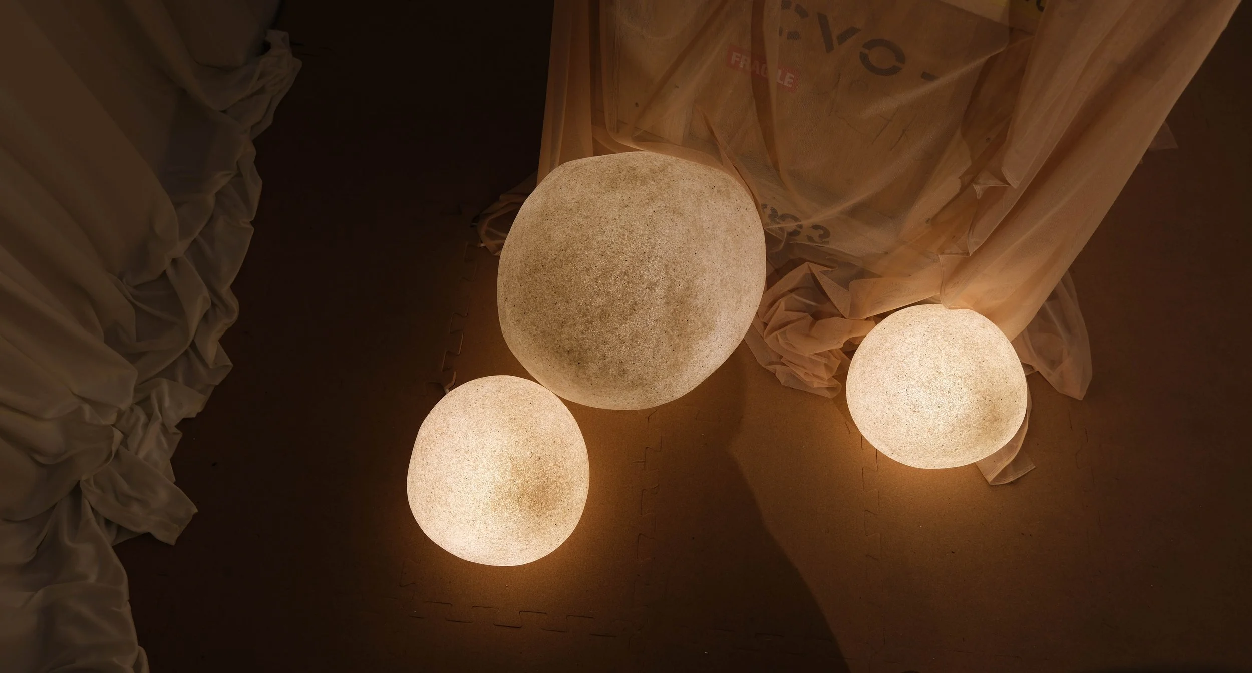 A black and white photo of a modern skyscraper taken from the ground looking up, showing windows and architectural details.