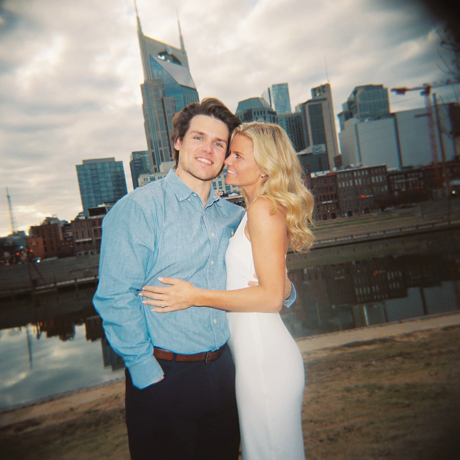 Engaged couple takes photo in front of Nashville skyline