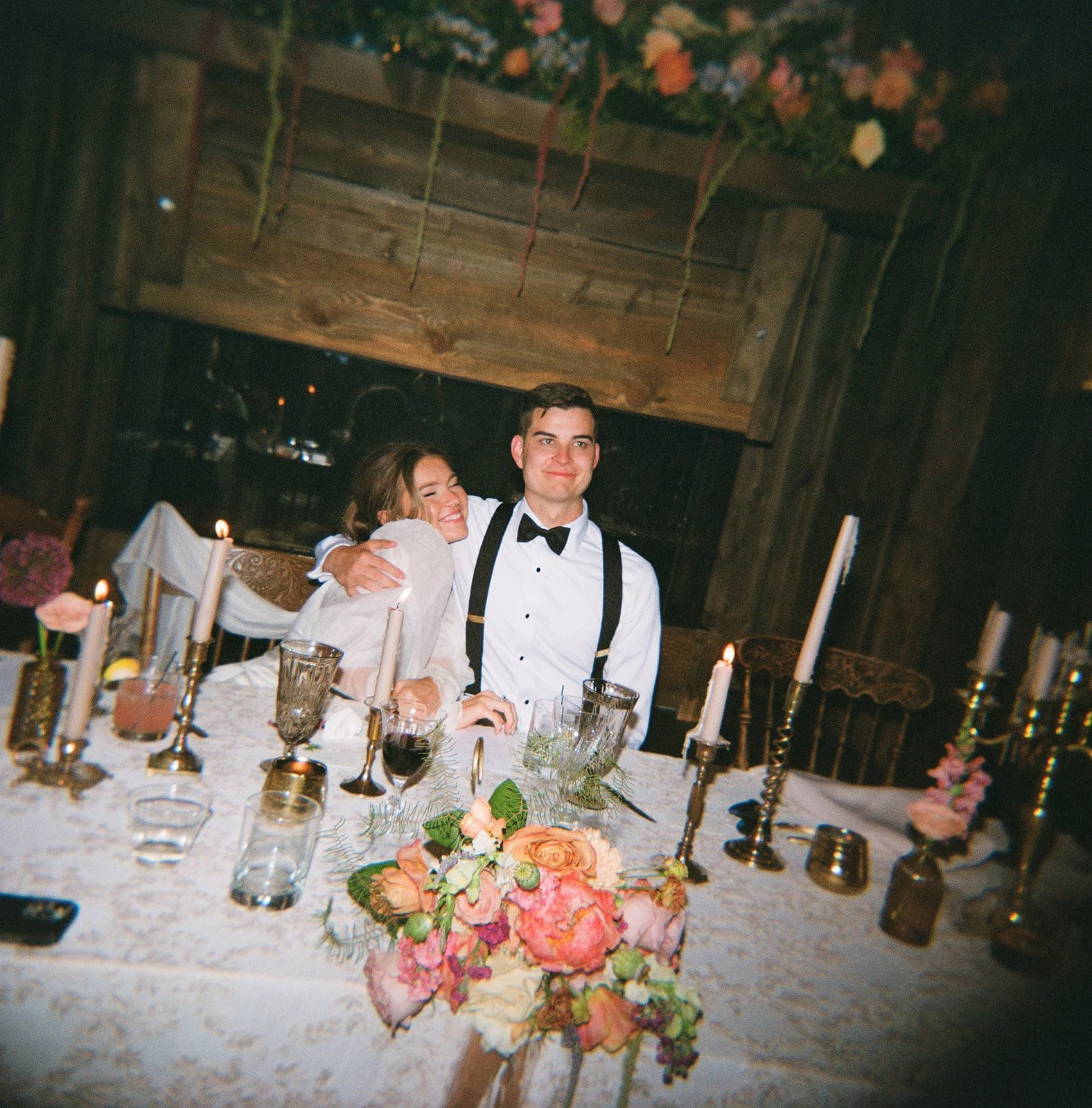 Bride and groom hugging at the sweetheart table