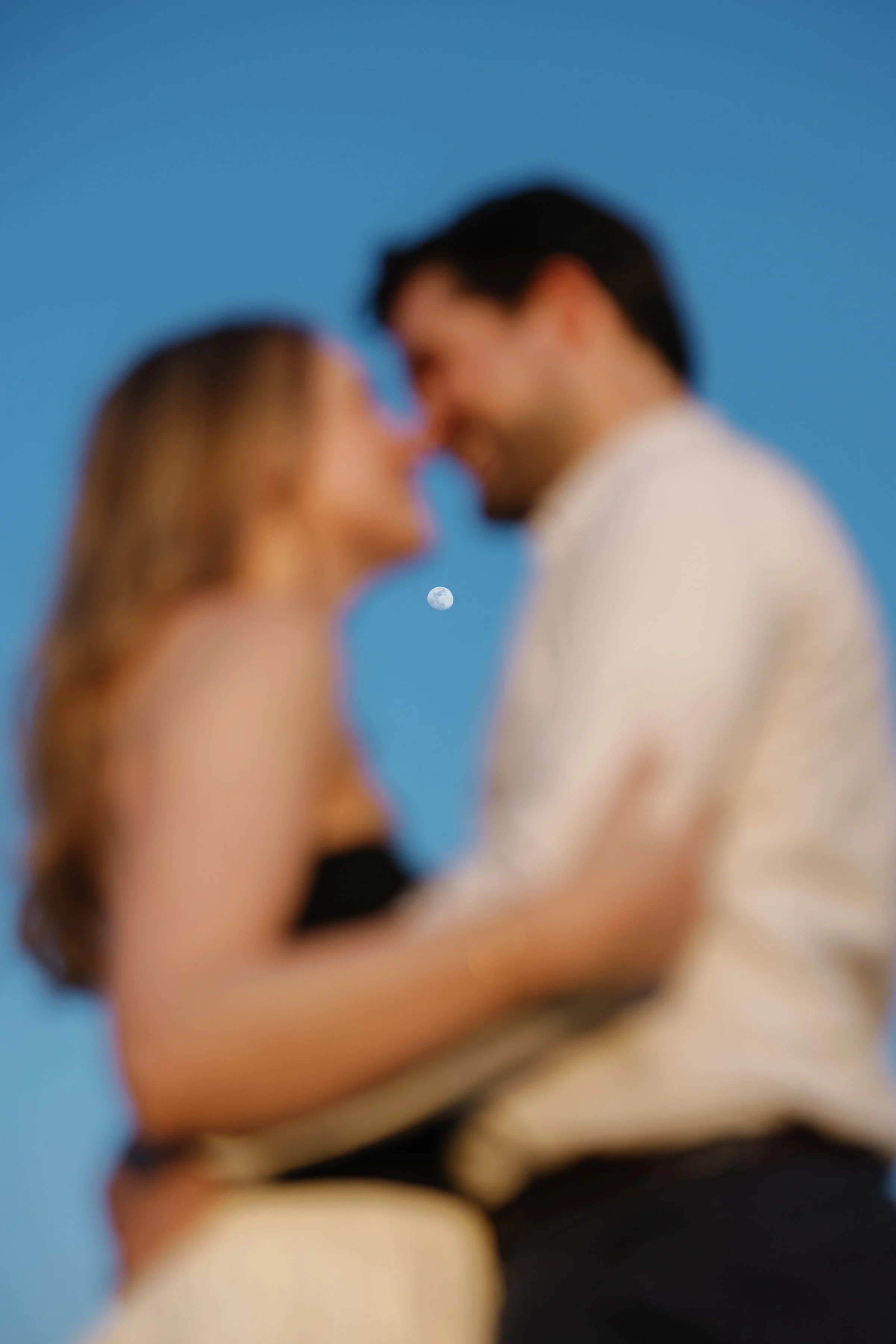 Proposal photo of woman and man blurry with the moon in the background