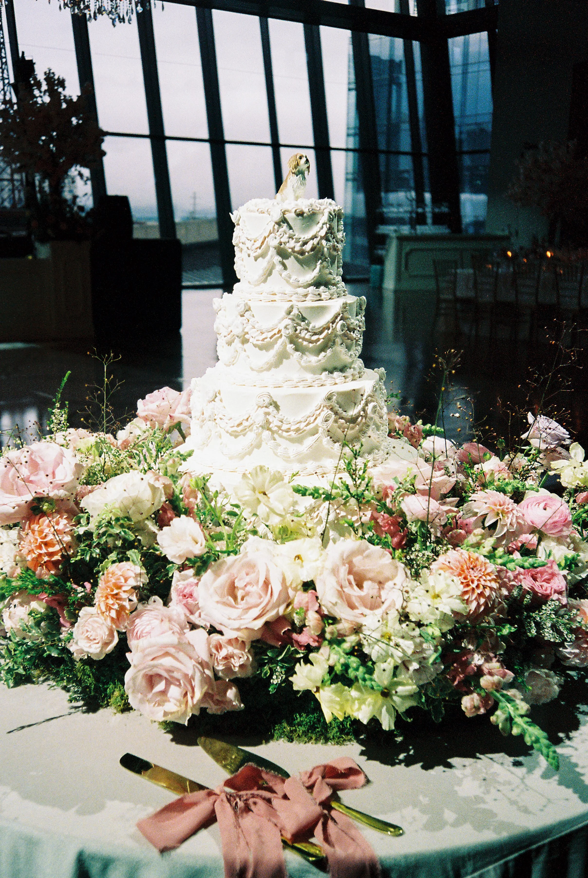 Multi-tier vintage wedding cake with florals around it
