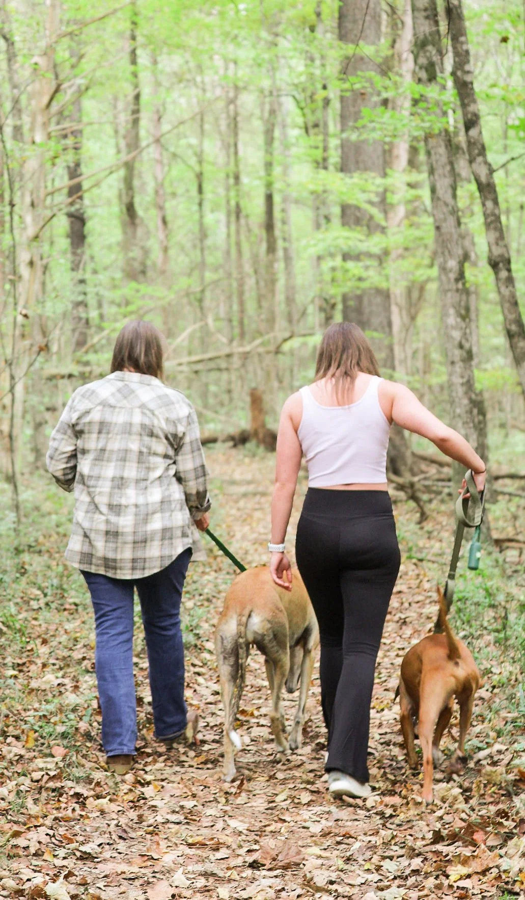 The owner of PetsTalkIListen.com and her daughter lovingly walking their dogs in the woods.