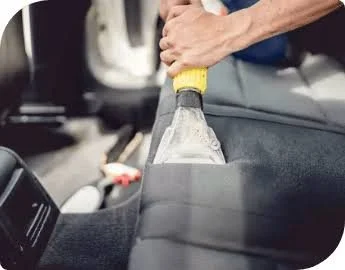 Person placing a plastic water bottle into a car's airbag compartment