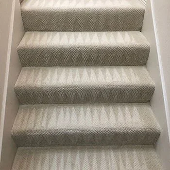 Carpeted staircase with patterned beige and light gray steps