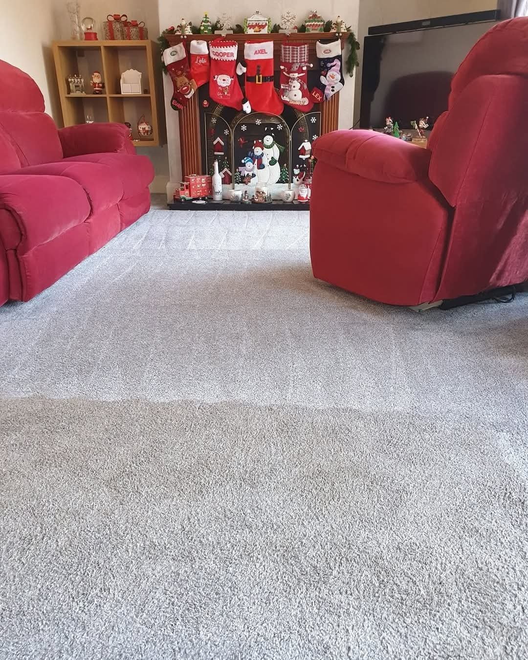 Living room with red sofas, a decorated fireplace with Christmas stockings, snowman figures, and holiday decorations.