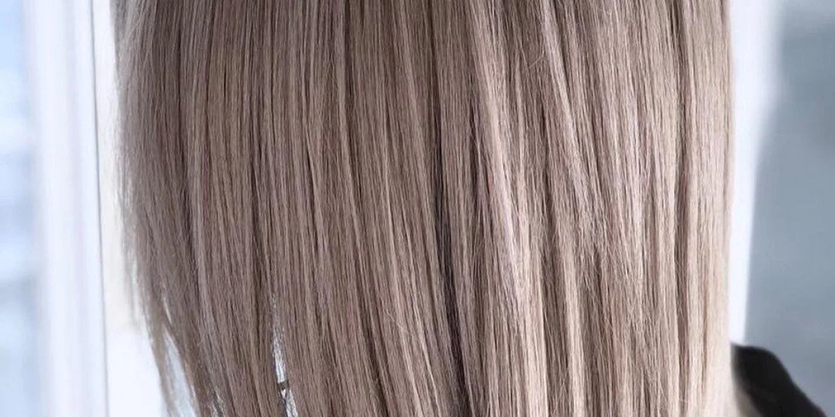 Close-up of a person with long, straight, platinum blonde hair.