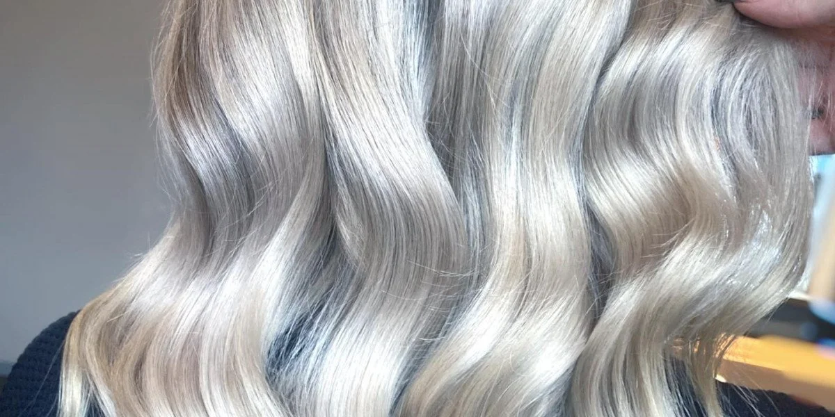 Close-up of wavy, platinum blonde hair on a person.