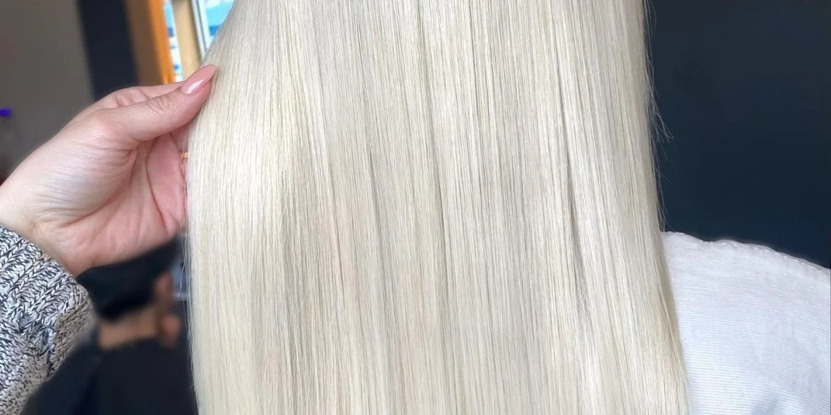 Close-up of a person with long, straight, platinum blonde hair.