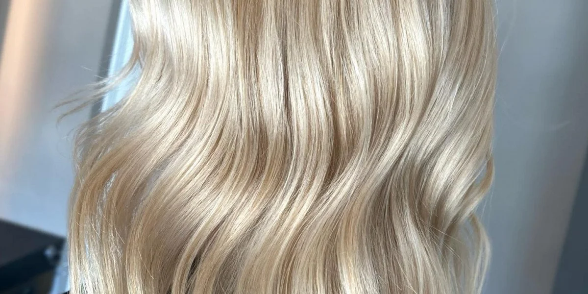 Close-up of wavy, blonde hair with highlights.
