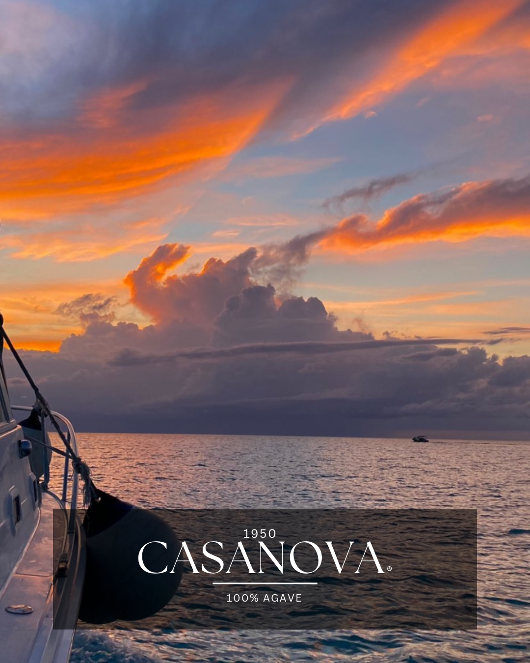Sunset over the ocean with clouds and a boat in the distance, seen from a boat with a fender in the foreground, and a label for Casanova 100% Agave.