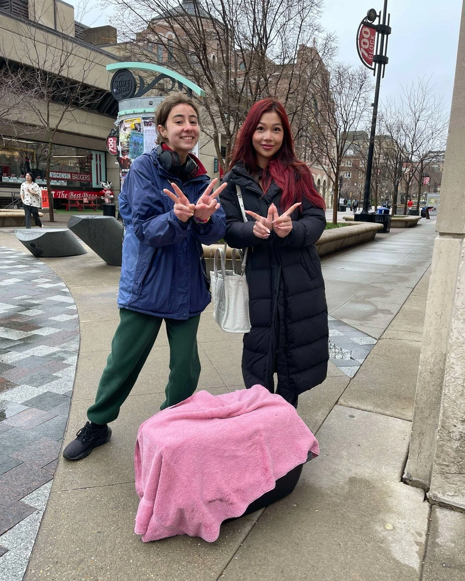 Two UW-Madison students on library mall standing near a pet carrier