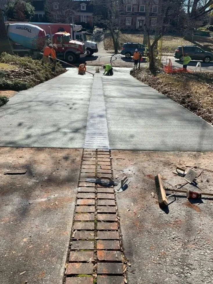 Concrete being poured and flattened out on a residental driveway