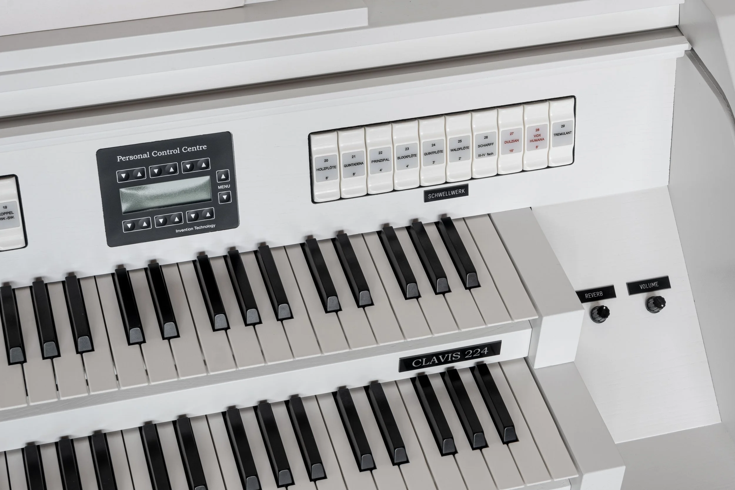 White digital organ with two manuals, numerous switches, and a small display screen, labeled 'CLAVIS 224'.