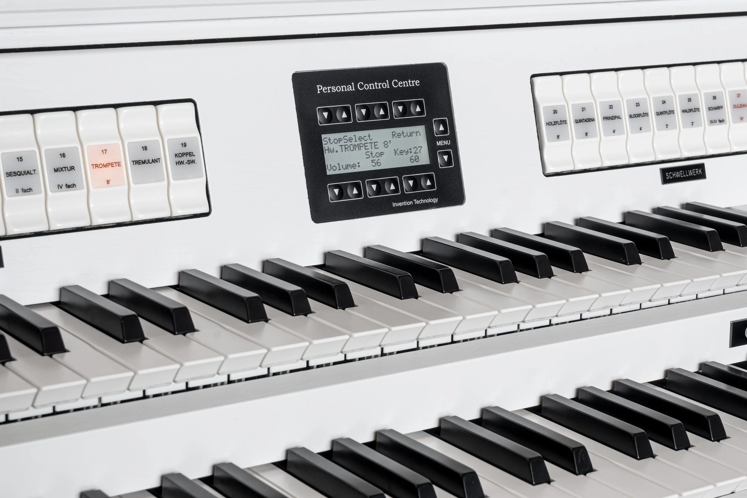 Close-up of a digital electronic keyboard with various control buttons, a display screen, and black and white keys.