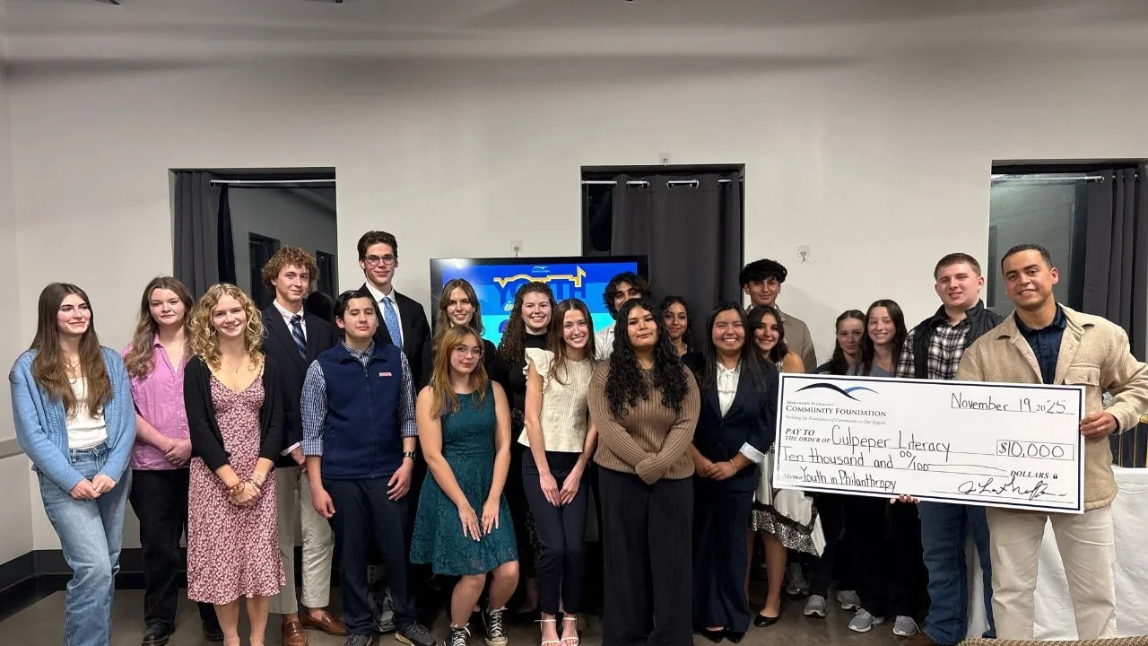 YIP 2025. Teens pose with the recipient of a large check