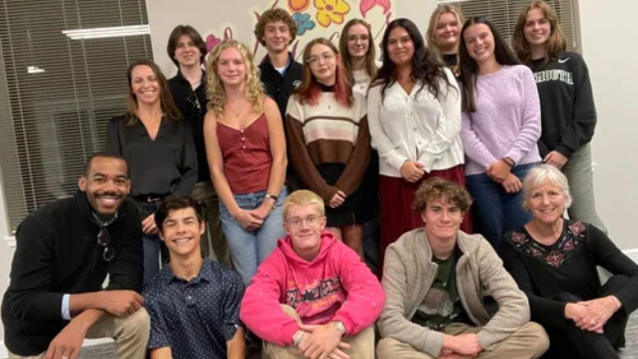YIP 2024. Teens pose in front of a wall with NPCF staff