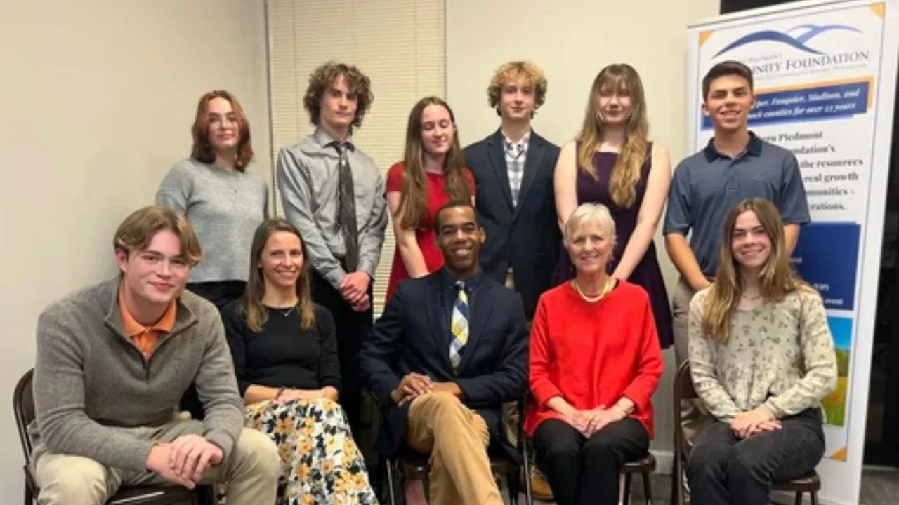 YIP 2023. Teens pose in front of a wall with NPCF staff