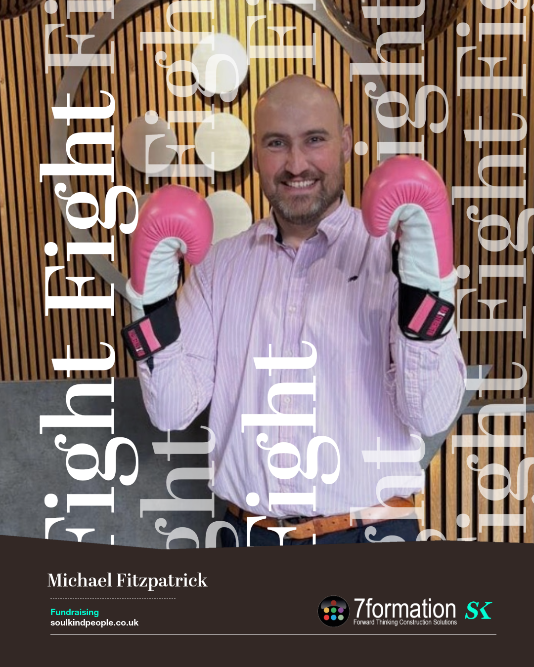 A man smiling and wearing boxing gloves in front of a wooden wall with decorative light fixtures, holding his fists up in a boxing stance.