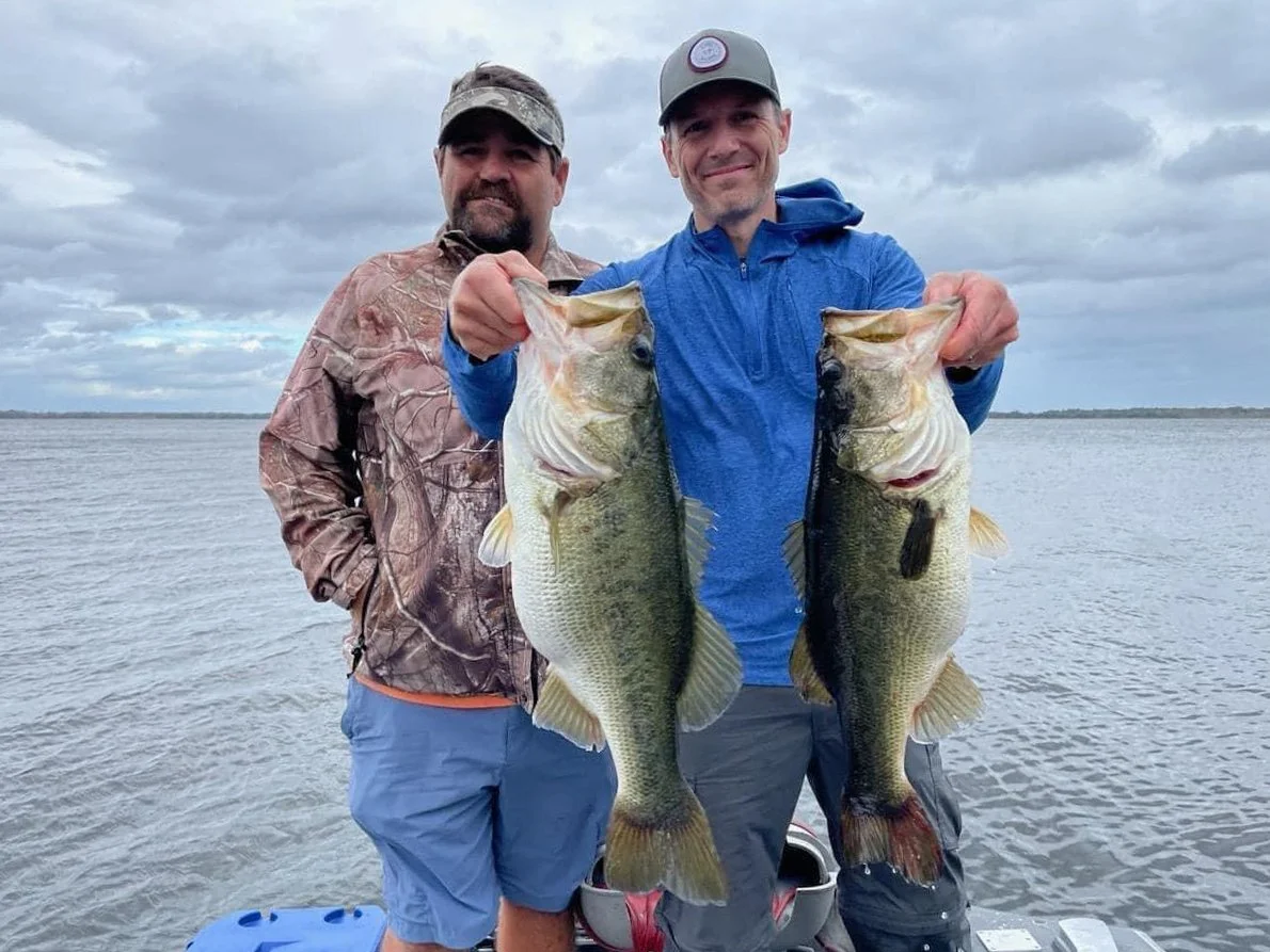 Guide and angler with two trophy size largemouth bass near Lake Woodruff, Florida.