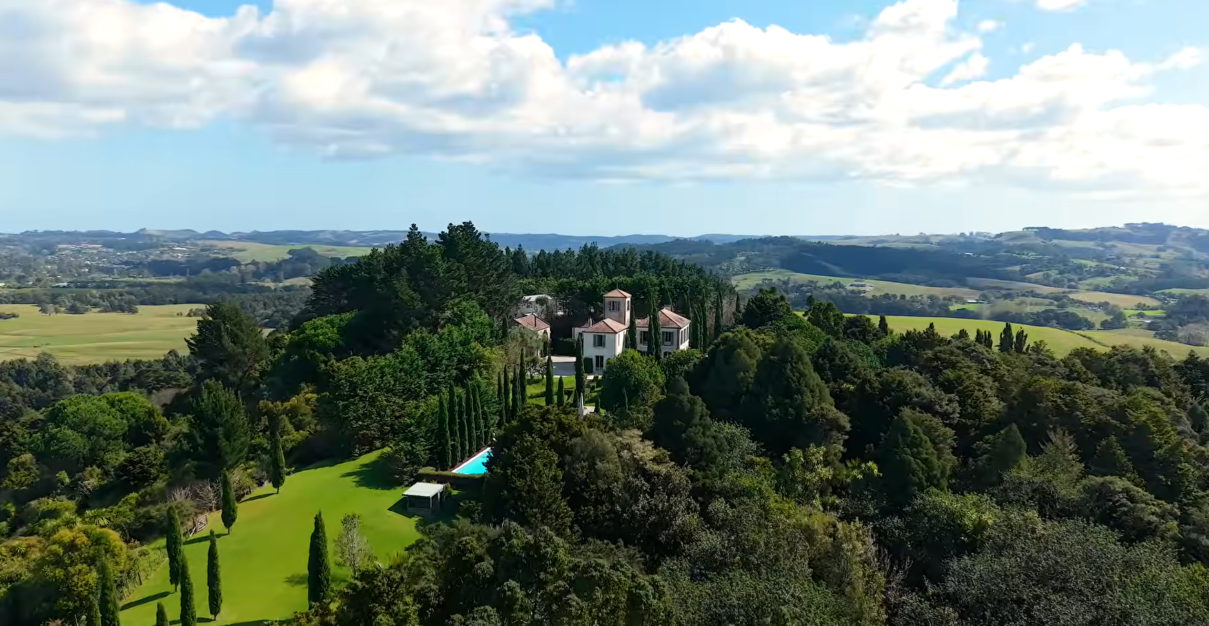 Luxury Tuscan-inspired estate at 909 Old North Road, Waimauku, Auckland, set on expansive rural land with manicured grounds, private pool, and elevated countryside views.