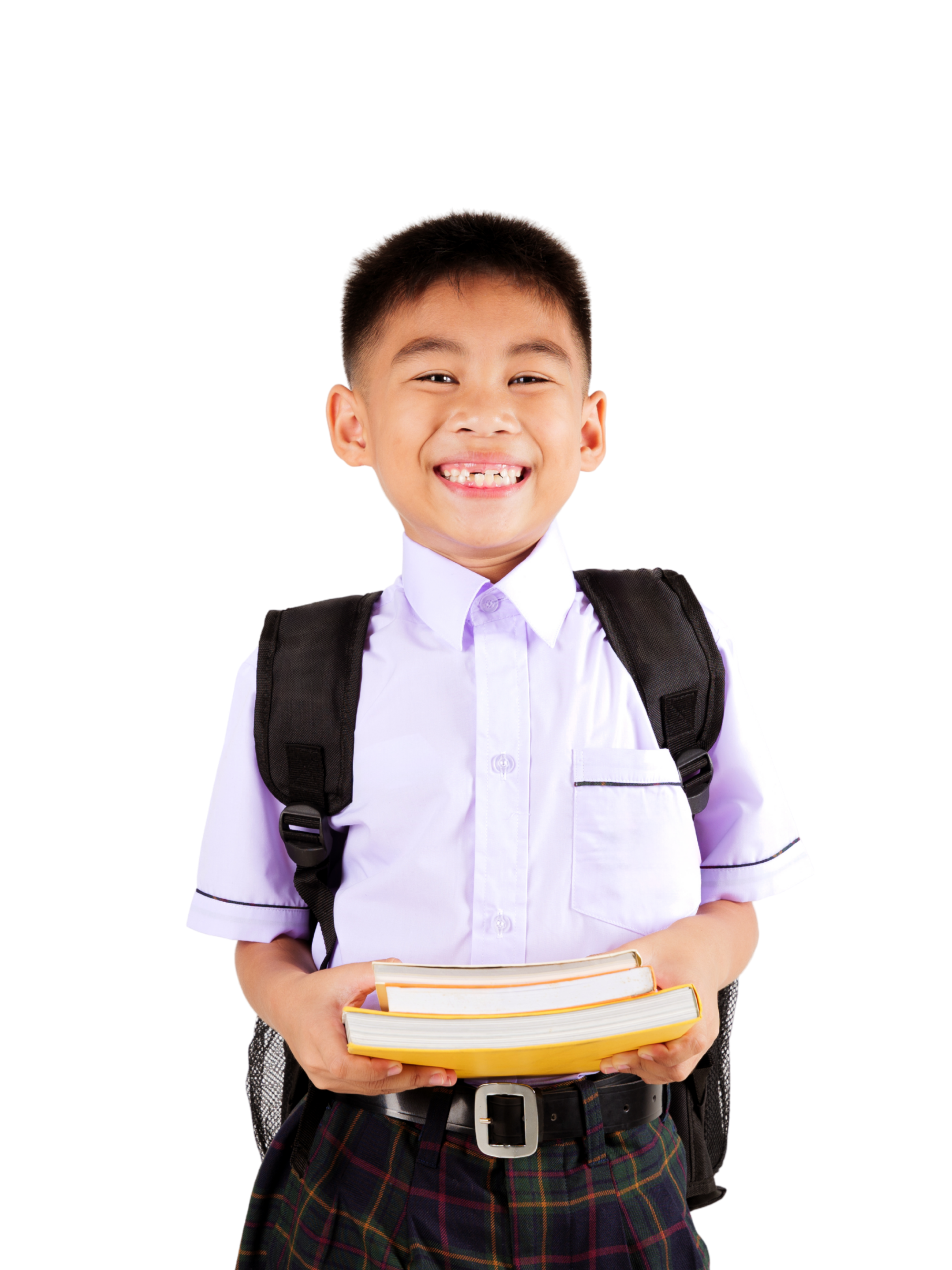 A young boy in school uniform holding a stack of books, smiling, with a backpack and plaid skirt, standing against a black background.