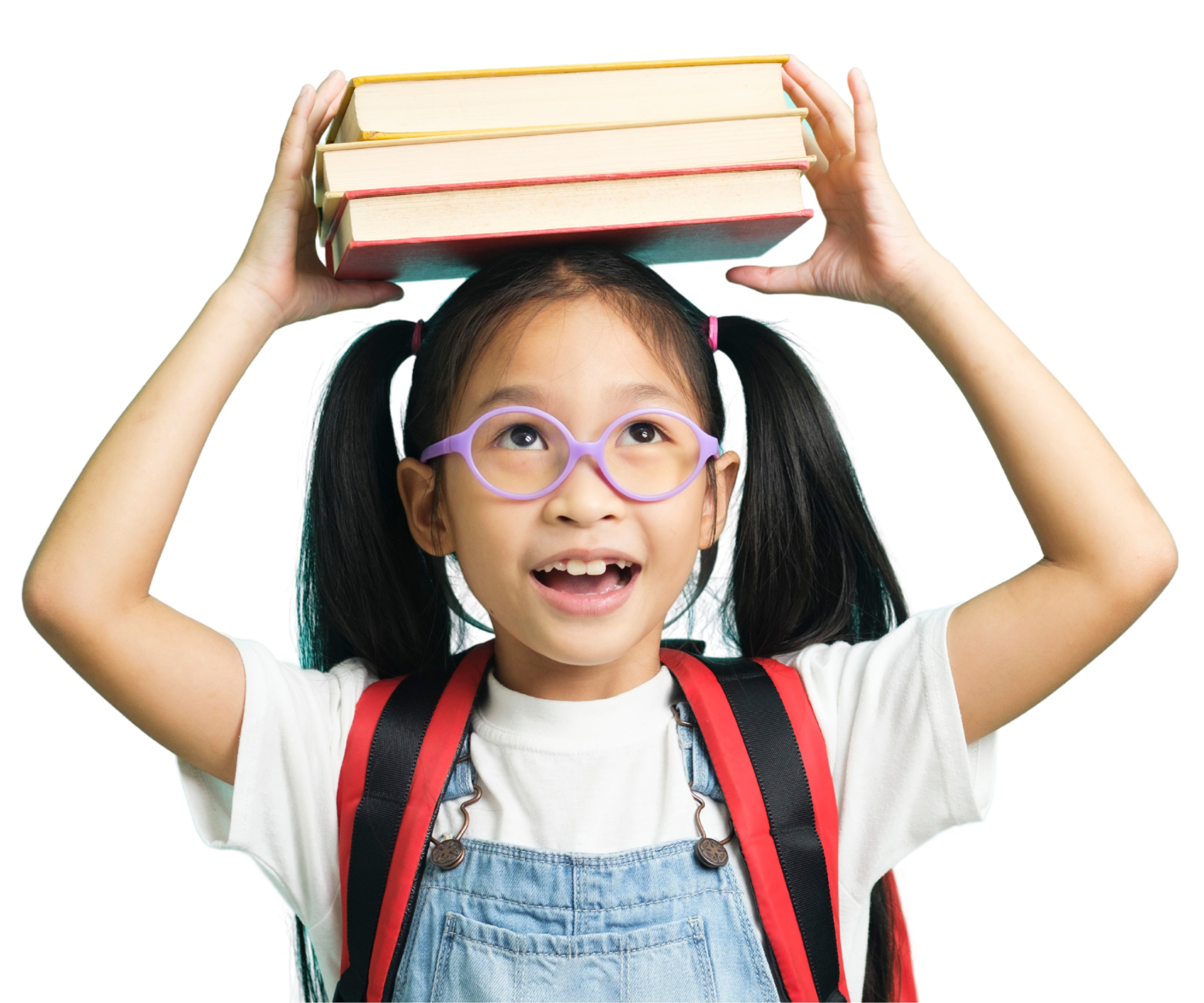 Young girl with glasses, pigtails, wearing a backpack, holding a stack of books on her head, smiling.