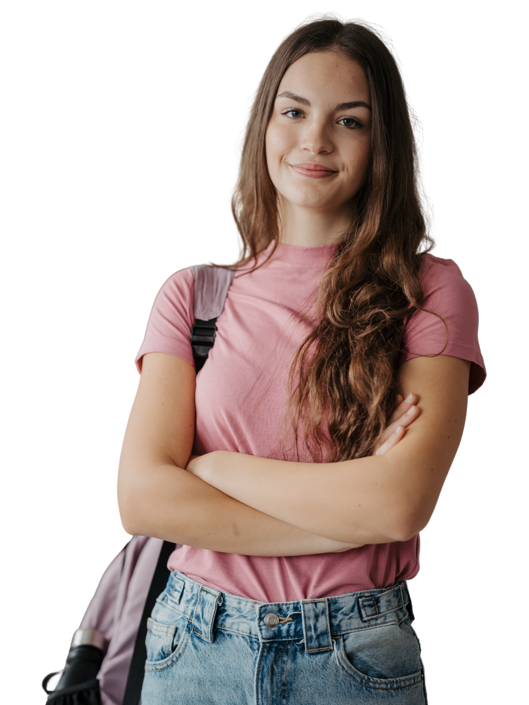A young woman with long brown hair and fair skin standing with crossed arms, wearing a pink T-shirt and high-waisted jeans.