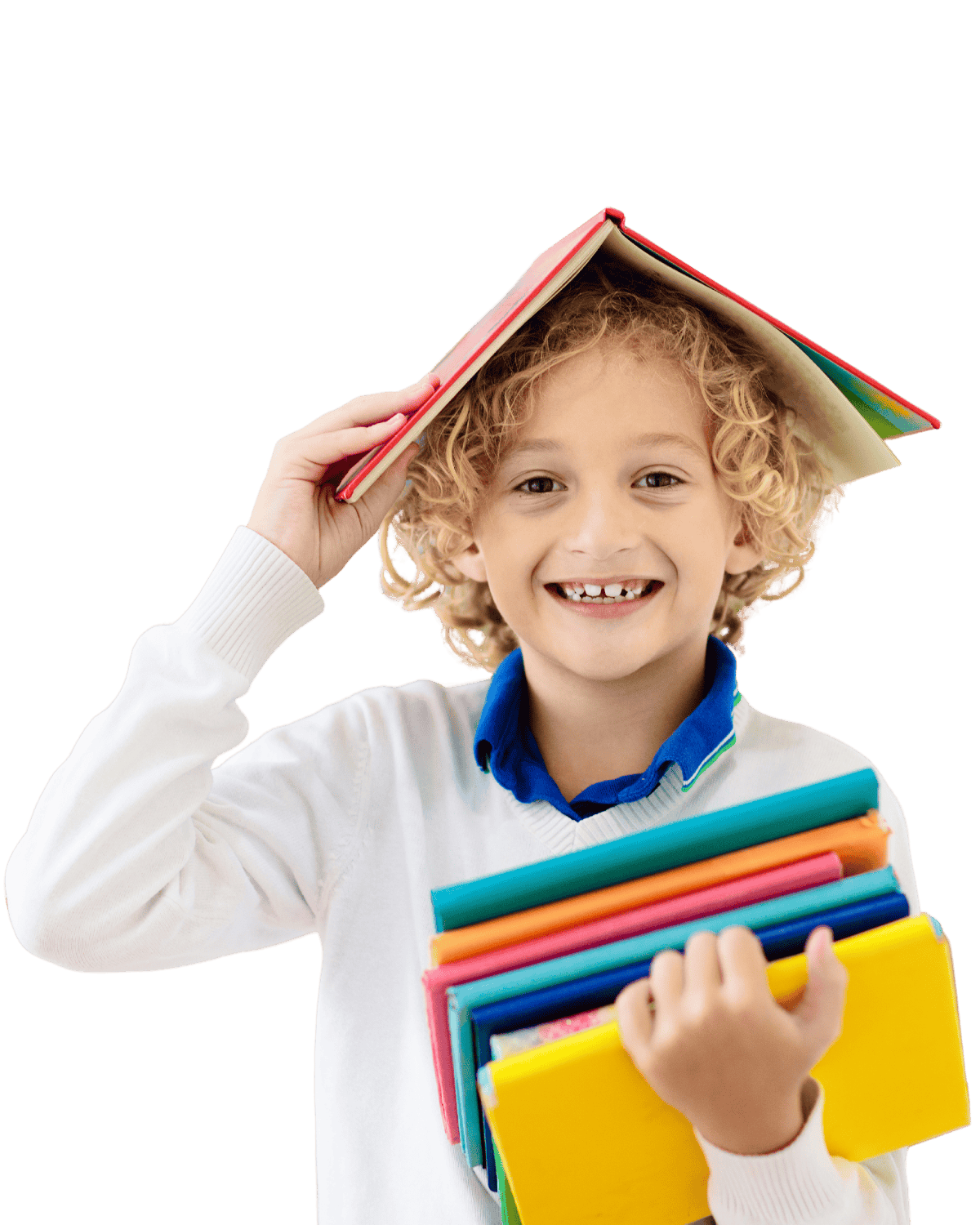 A young boy with curly blond hair and gaps in his teeth smiling while holding colorful books and balancing a book on his head.