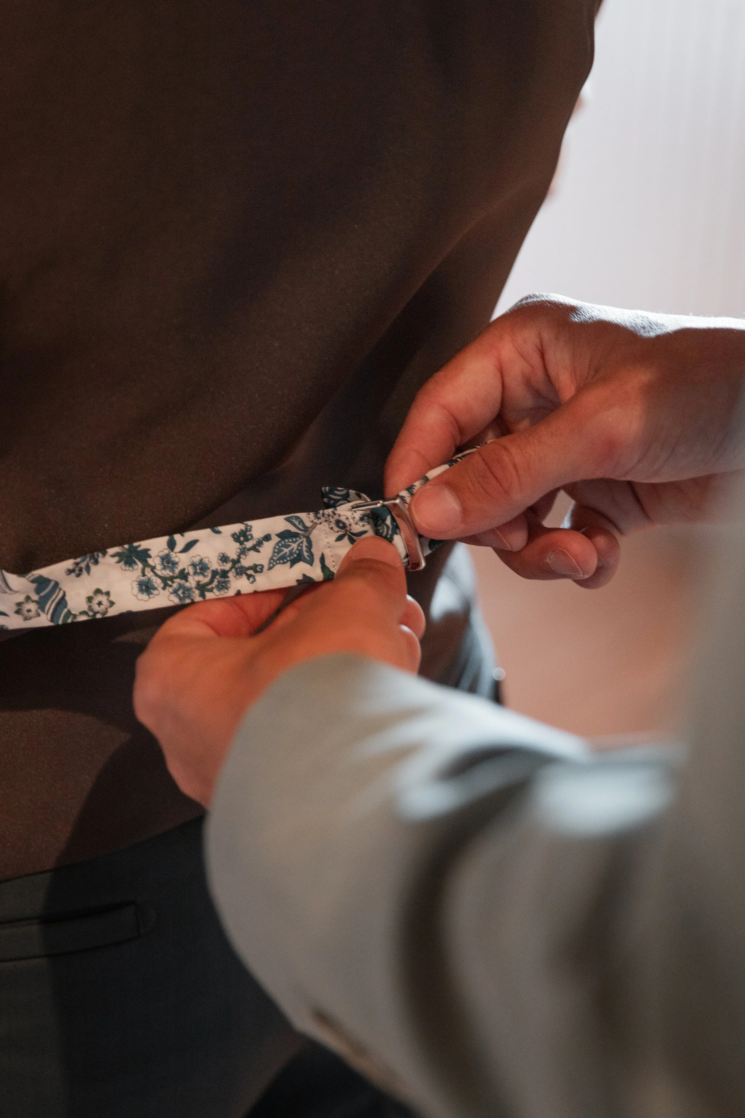 Personnis en train de fixer une ceinture à la taille d'une autre personne