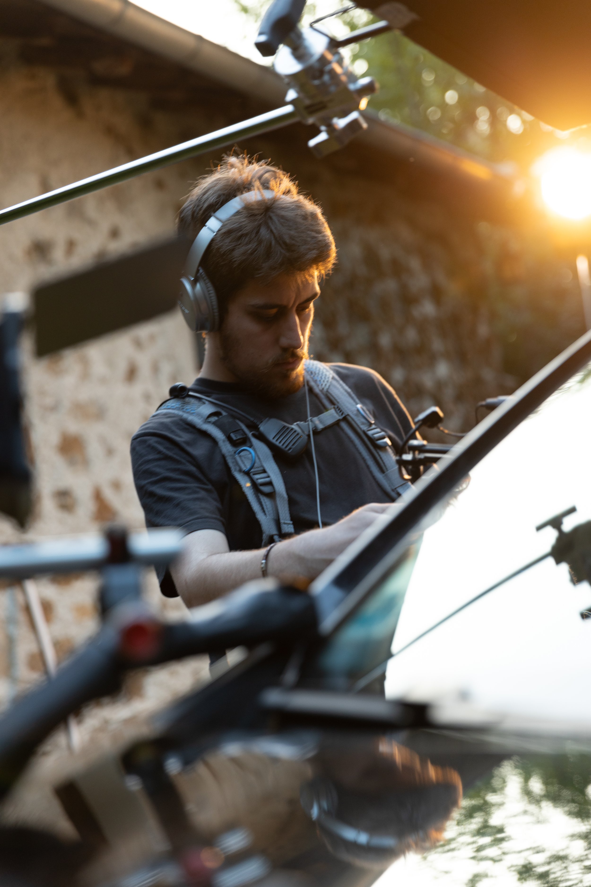 Un homme avec un casque de réalité virtuelle utilisant un drone ou un équipement technologique lors du coucher du soleil.