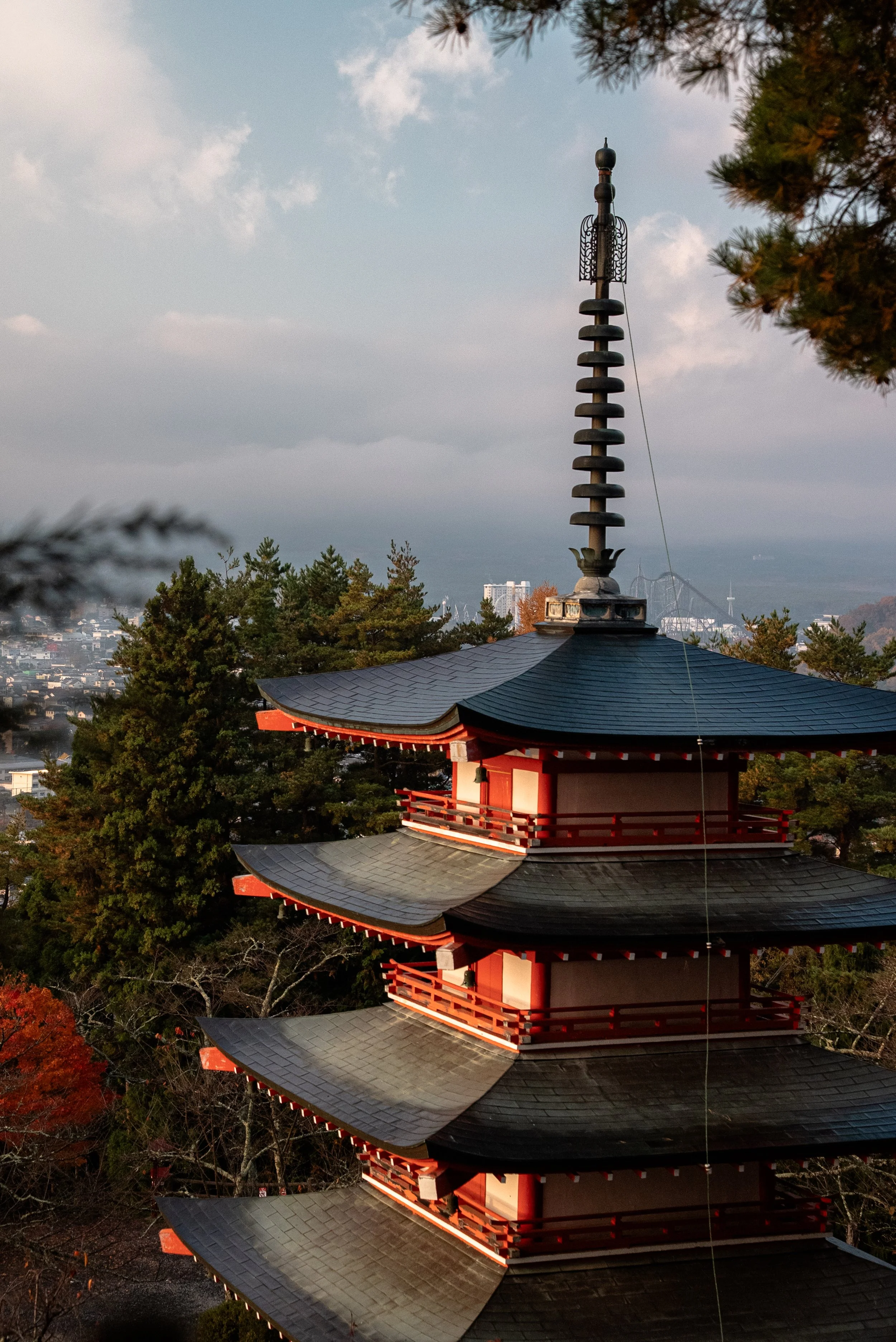 Pagode traditionnelle en bois à plusieurs étages avec toits incurvés, située dans un environnement arboré.