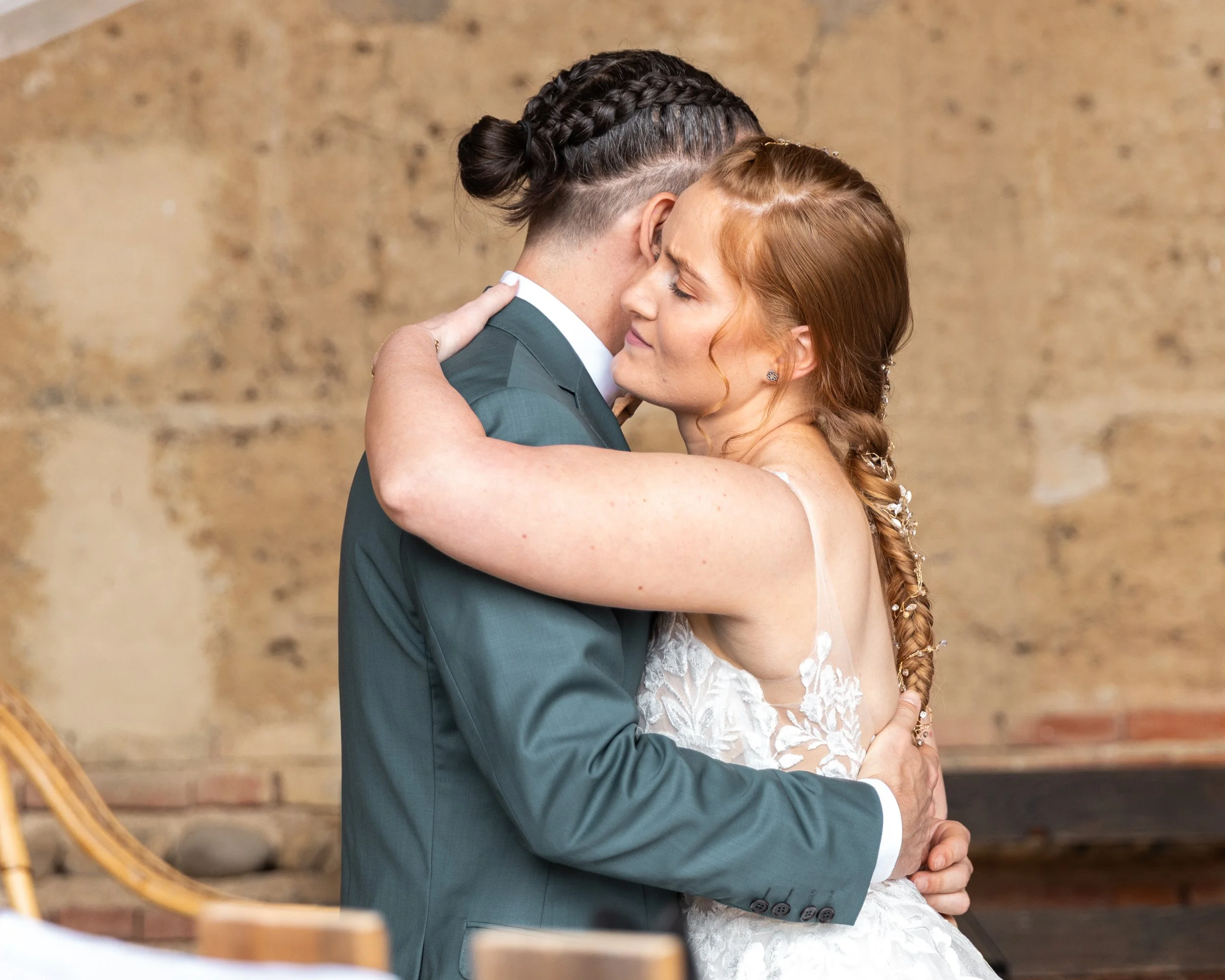 Un couple en robe de mariée et costume s'embrassant lors d'une cérémonie de mariage.