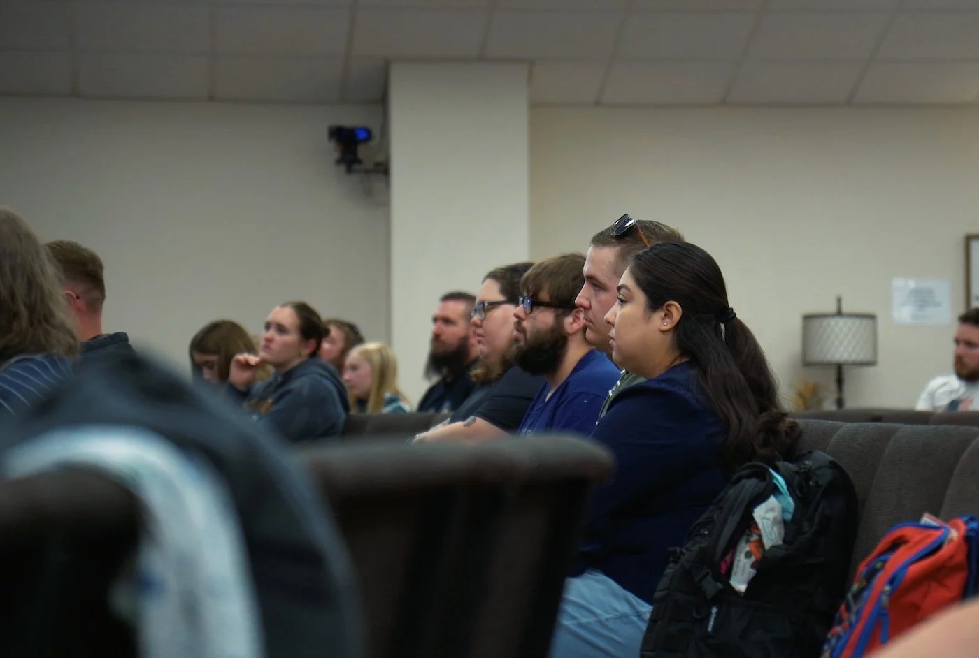 A group of people sitting in a conference room listening to a presentation.