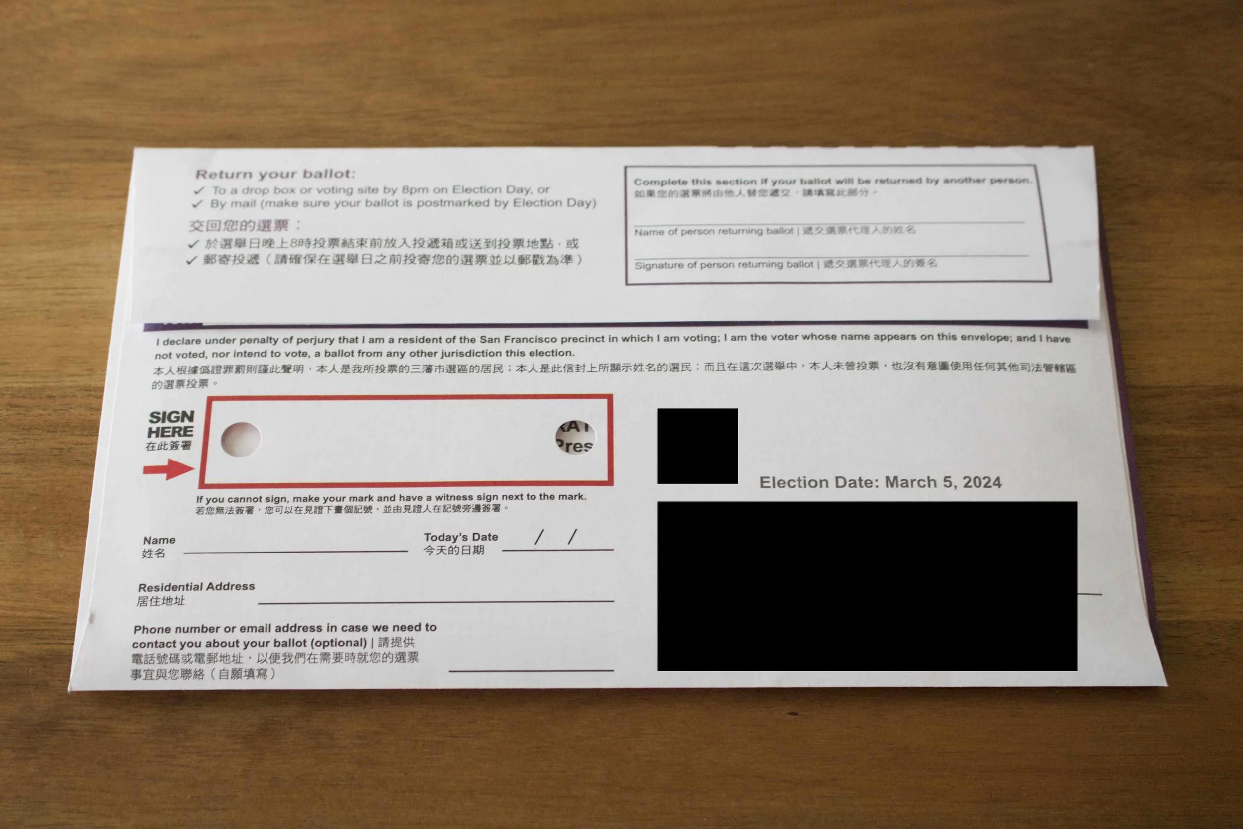The back of the return envelope, with its red signature blank and various other fields. The voter's address has been blacked out.