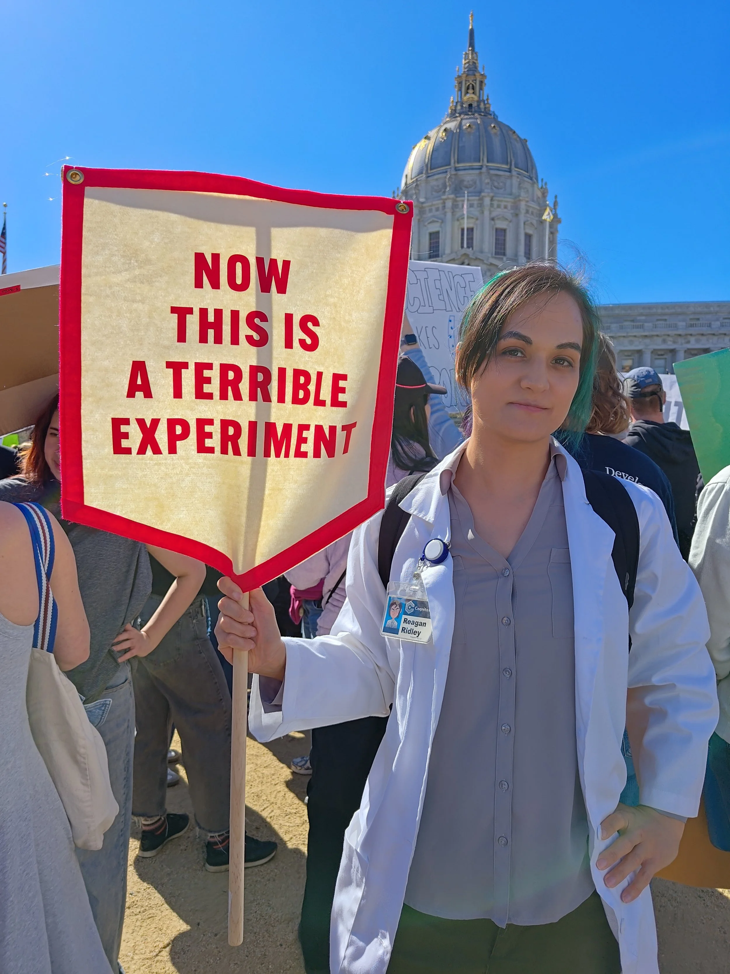 Protester holding a sign: “Now this is a terrible experiment.”