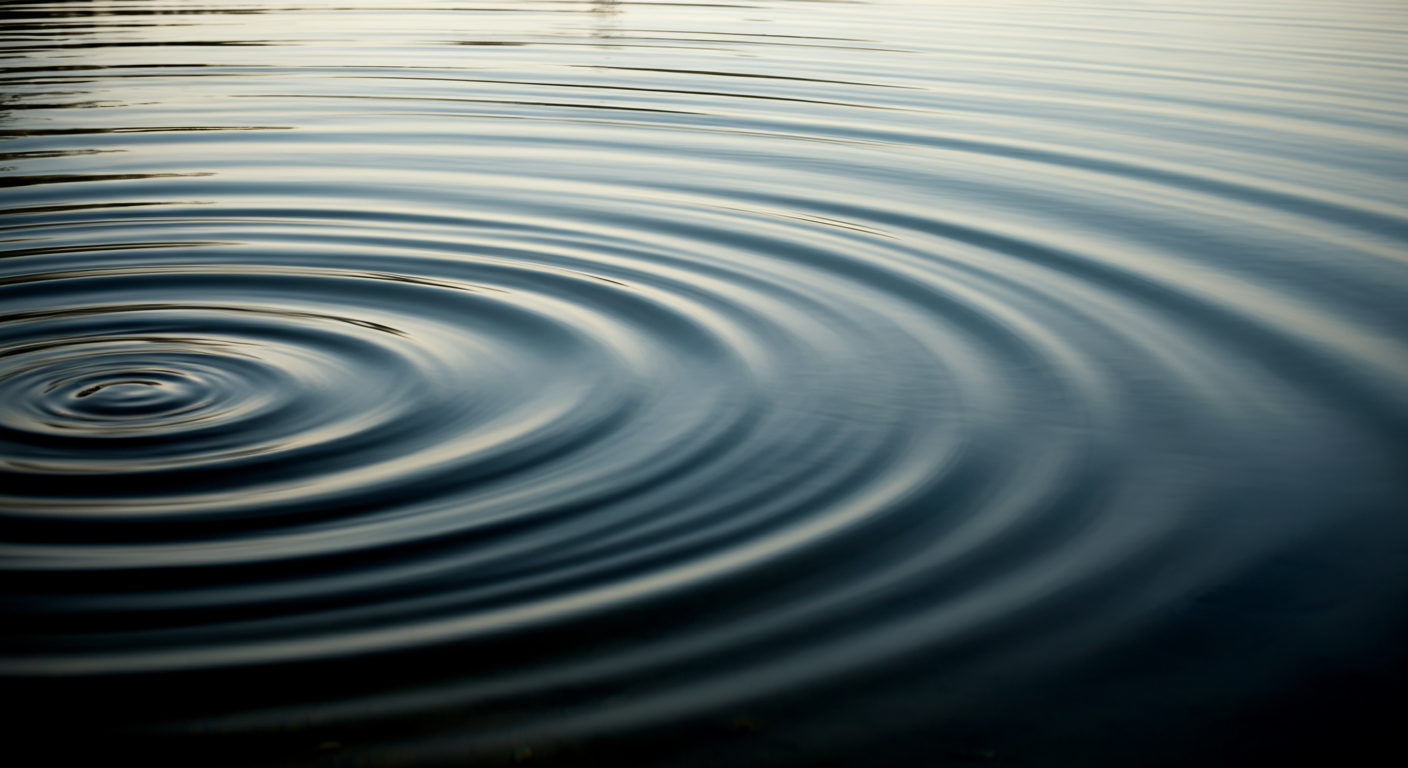 Close-up of water surface with ripples caused by a disturbance.