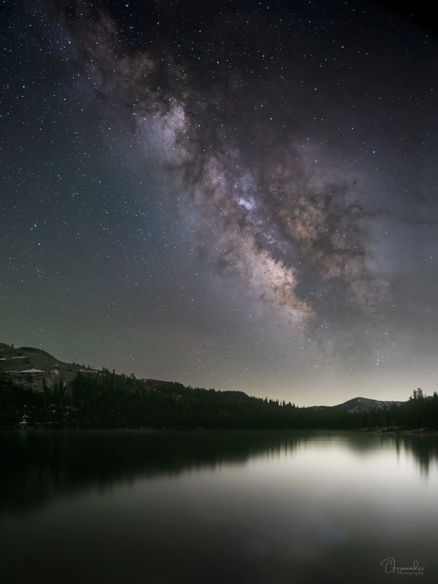 Milky way core aligned over Tenaya Lake with Pywiack Dome in Yosemite