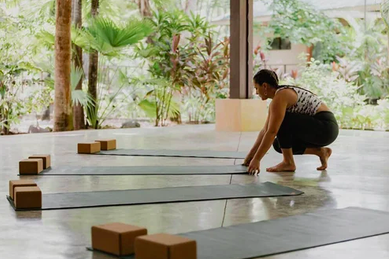 yoga teacher arranging yoga mats in a yoga shala at women's costa rica yoga retreat 