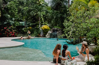 women lounging by a pool at a yoga retreat
