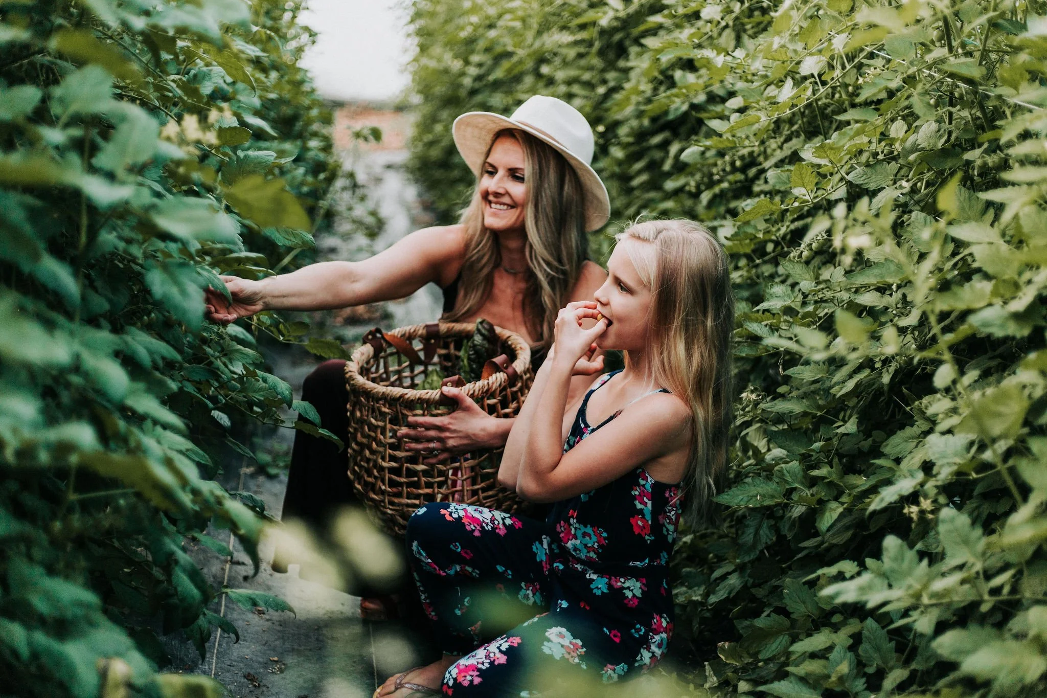 mother and daughter eating organic vegetables from the greenhouse in watseka