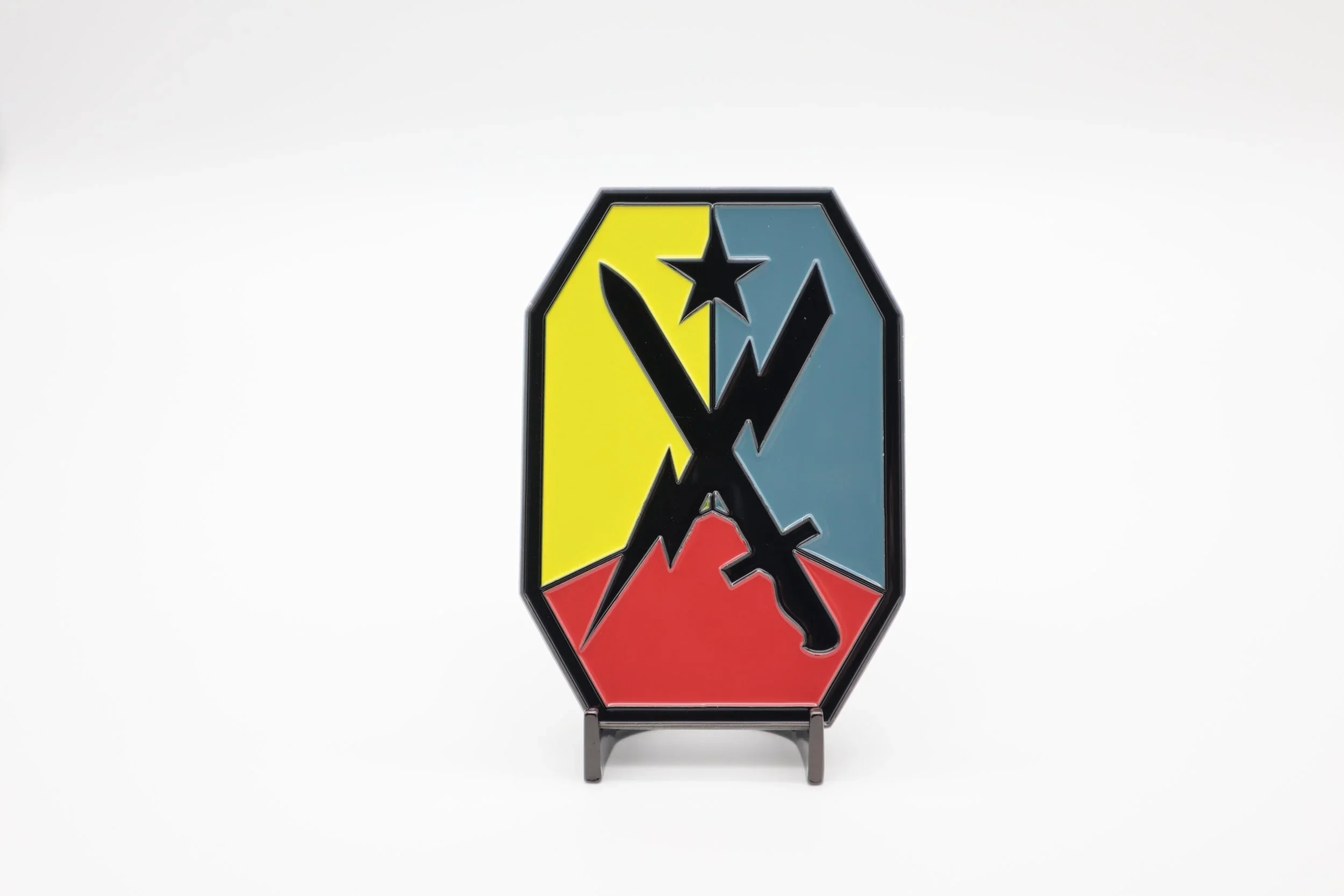 A decorative piece of art with a diamond-shaped design divided into four colorful triangles, featuring a silhouette of a horse and a star in the center, mounted on a small stand.