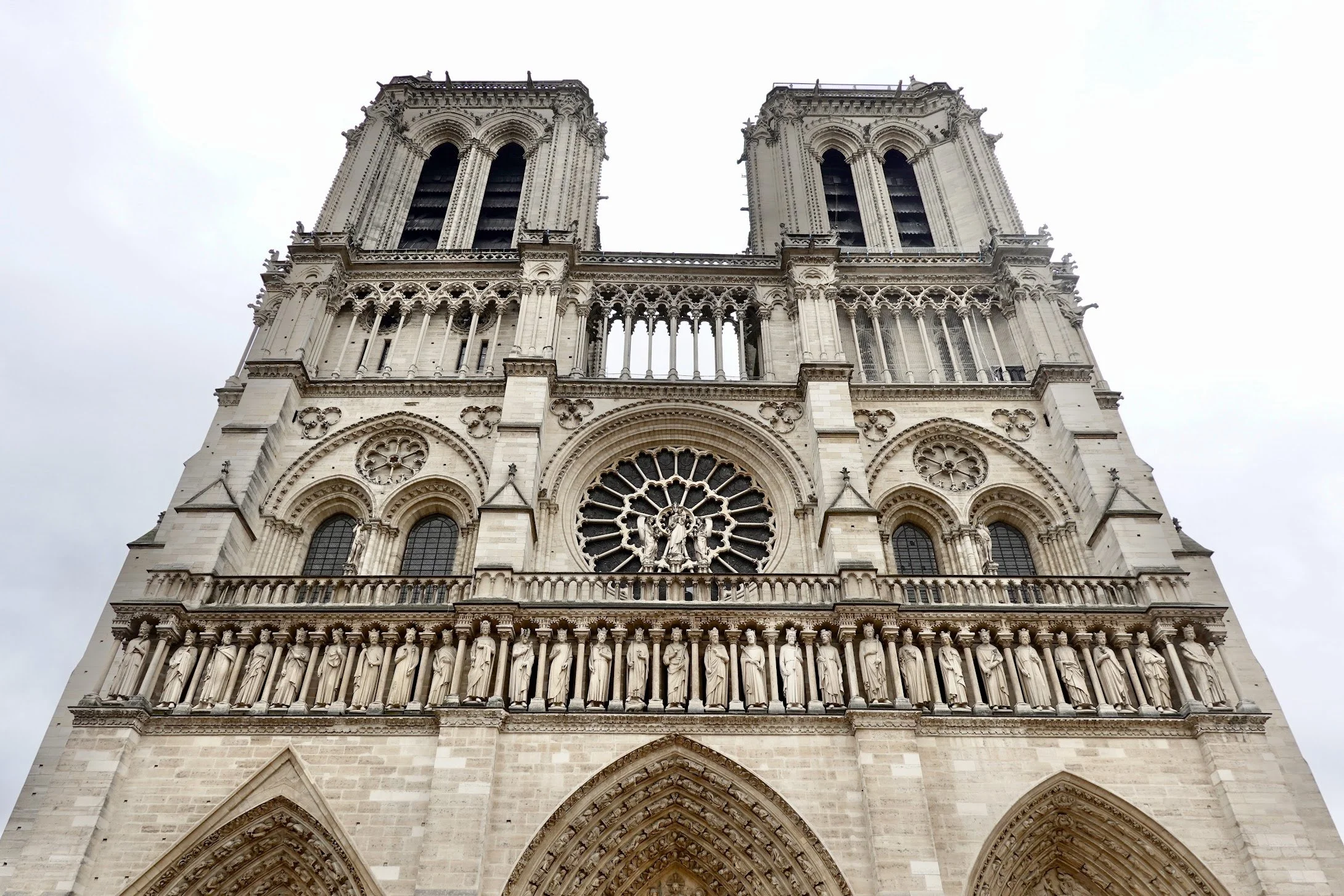 Front view of Notre-Dame Cathedral in Paris, showcasing its Gothic architecture, detailed sculptures, and large rose window.