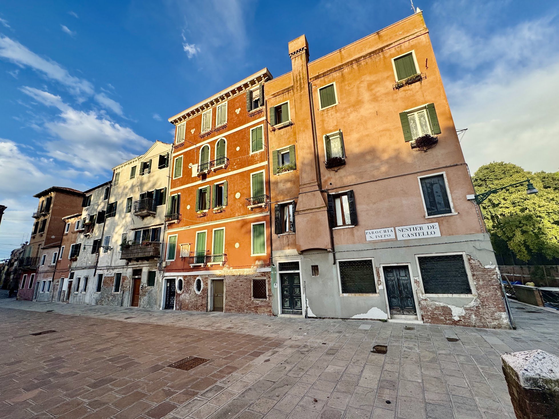 Colorful residential buildings along a street with a clear blue sky above.