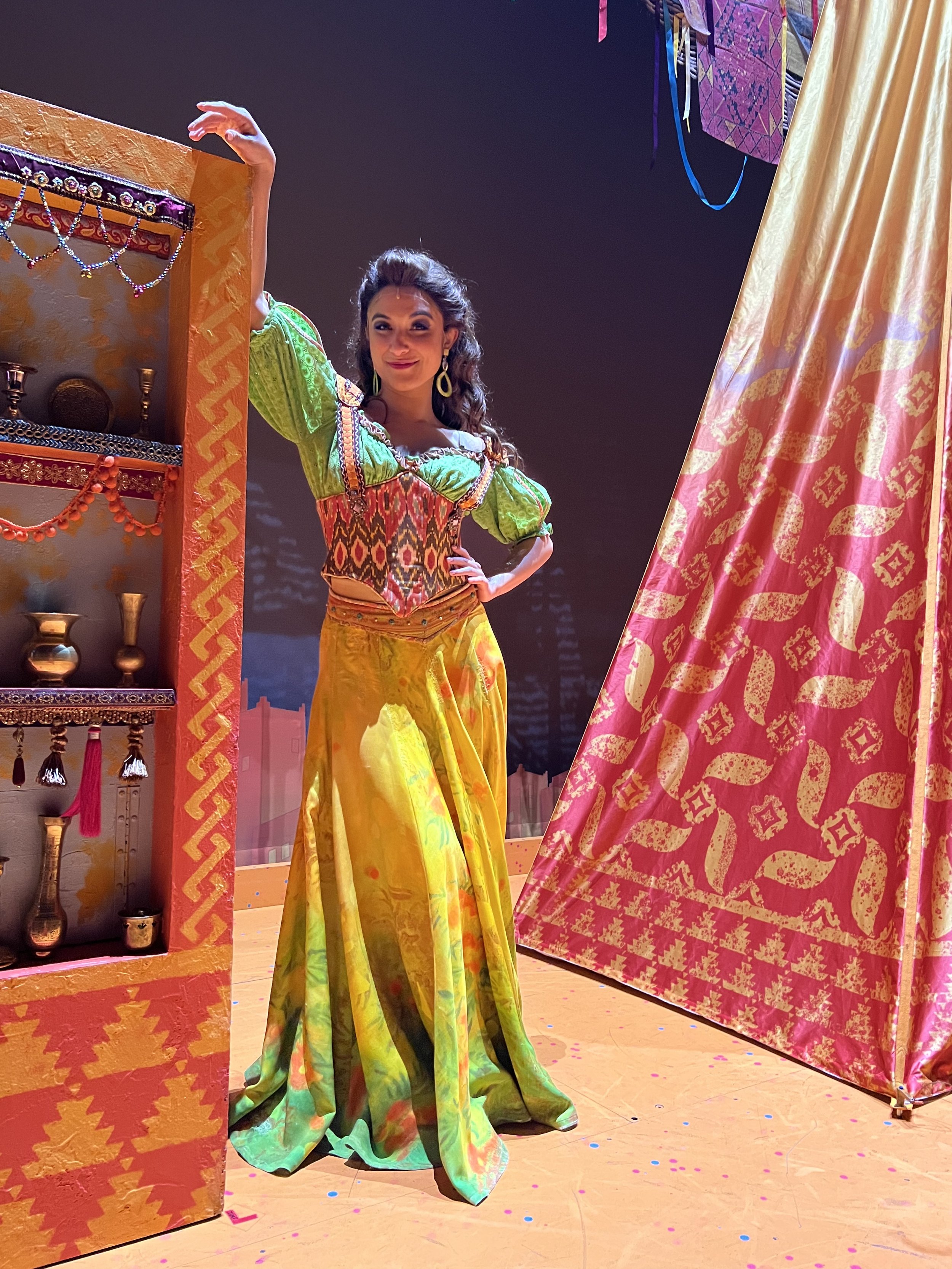 Tara posing in Aladdin, wearing a colorful costume
