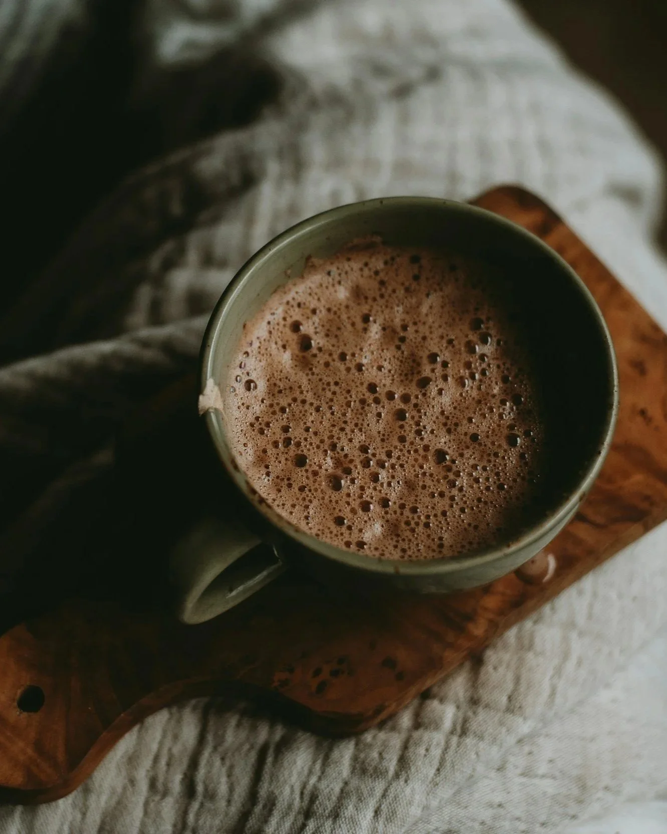 warm foamy cacao drink in a green mug