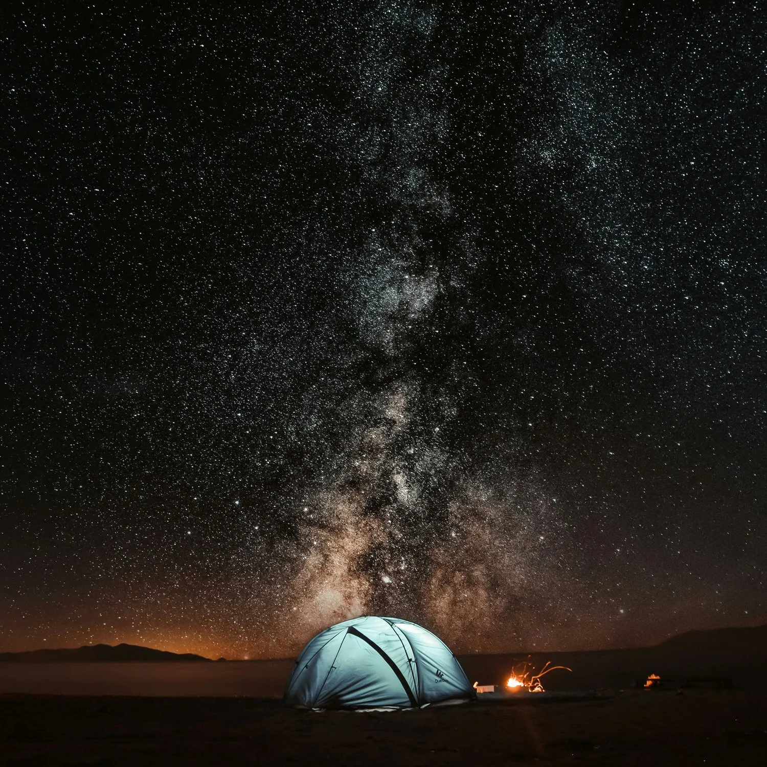 Tent camping at night with shining stars above.