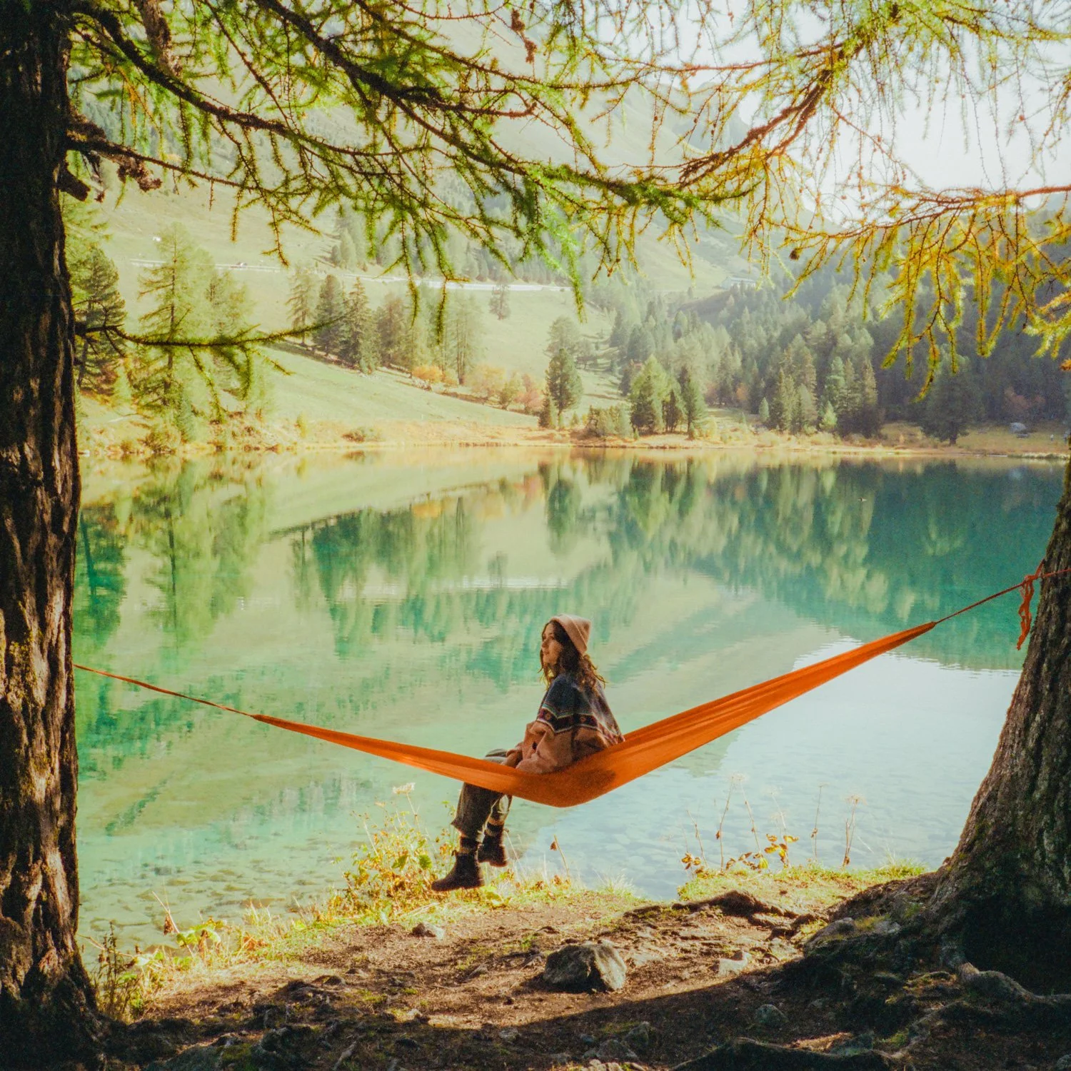 Camper sits on a hammock.