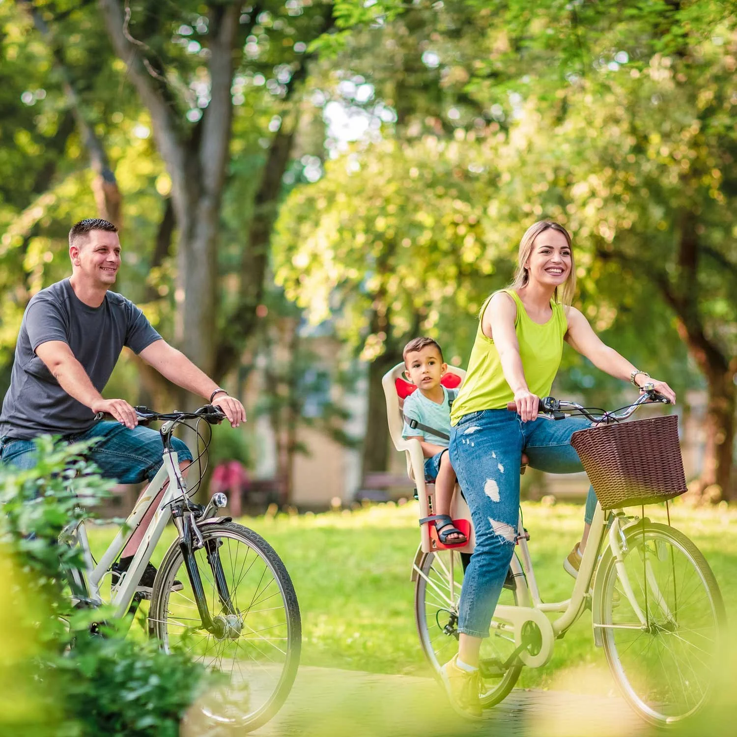 A family stays active by cycling through a park outdoors.