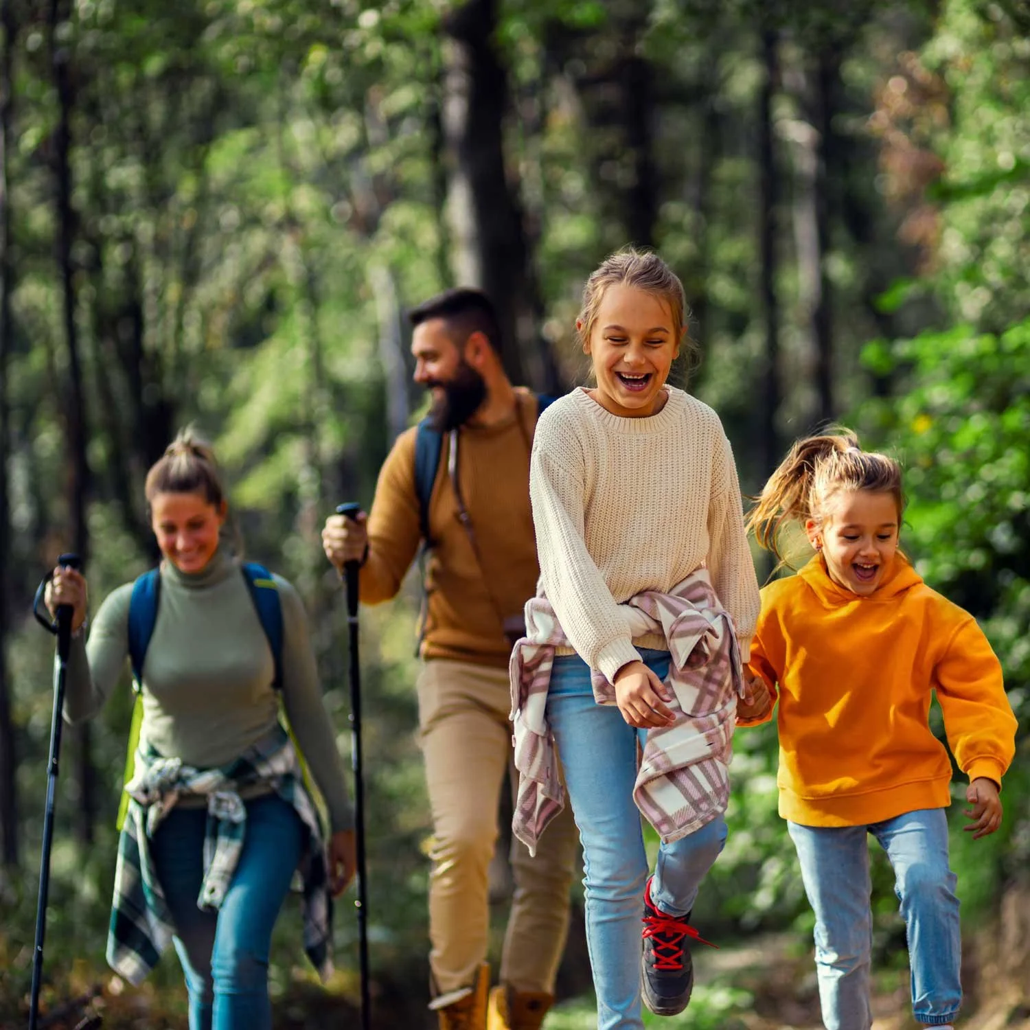 A family walks through the woods together.